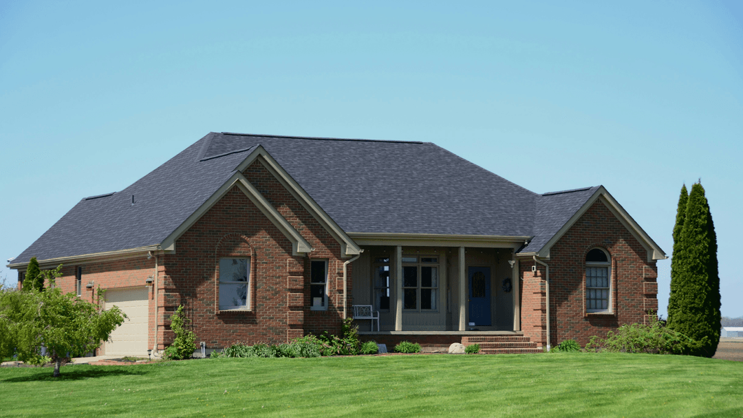Modern Red-Brick House Surrounded By A Freshly Mowed Lawn
