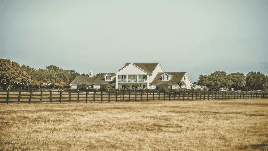 Country manor surrounded by trees and acres of land.