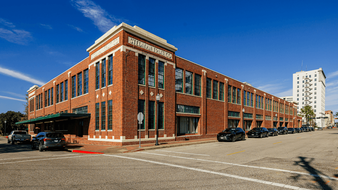 Elongated brick building on a busy urban street.