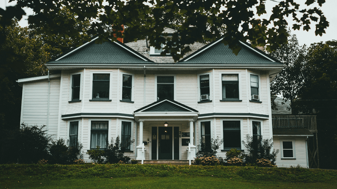 Three-Story White And Green Wooden Home