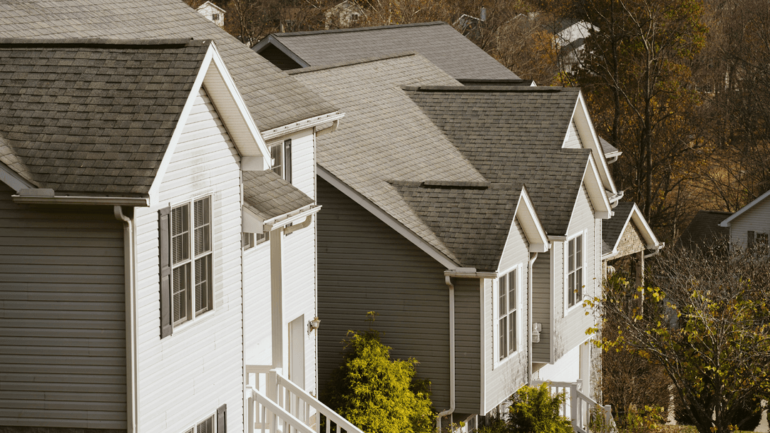 Row of gray homes with white trimming on a suburban road