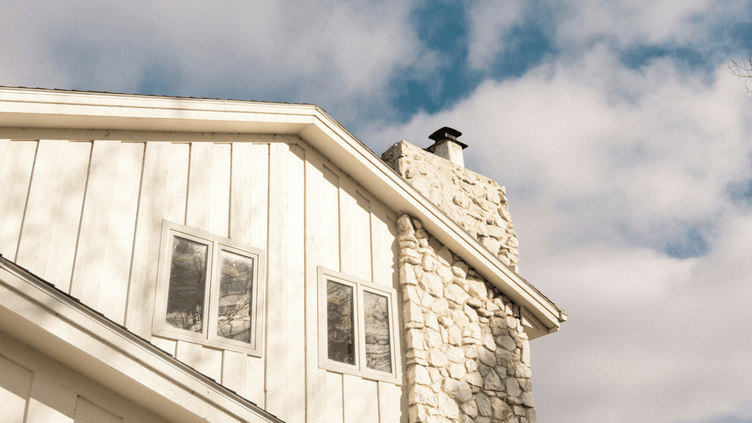 Wooden home with a white stone chimney and white trimmings