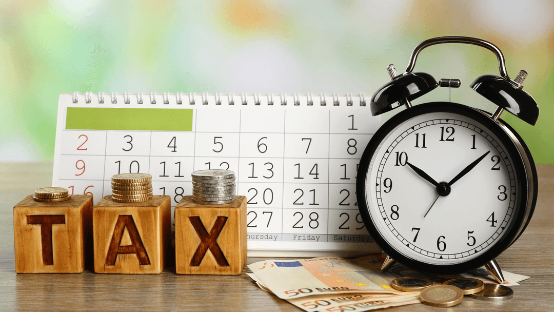 Alarm clock and calendar next to tax blocks for Texas monthly property tax planning