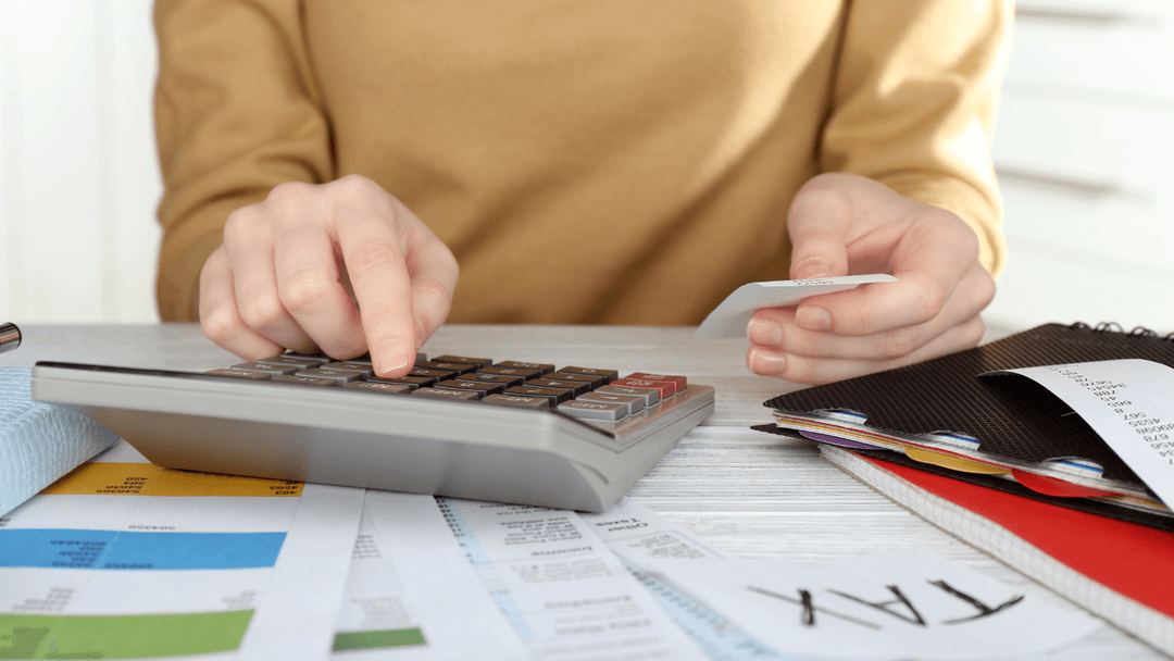 Homeowner calculating property tax bill with receipts and financial documents