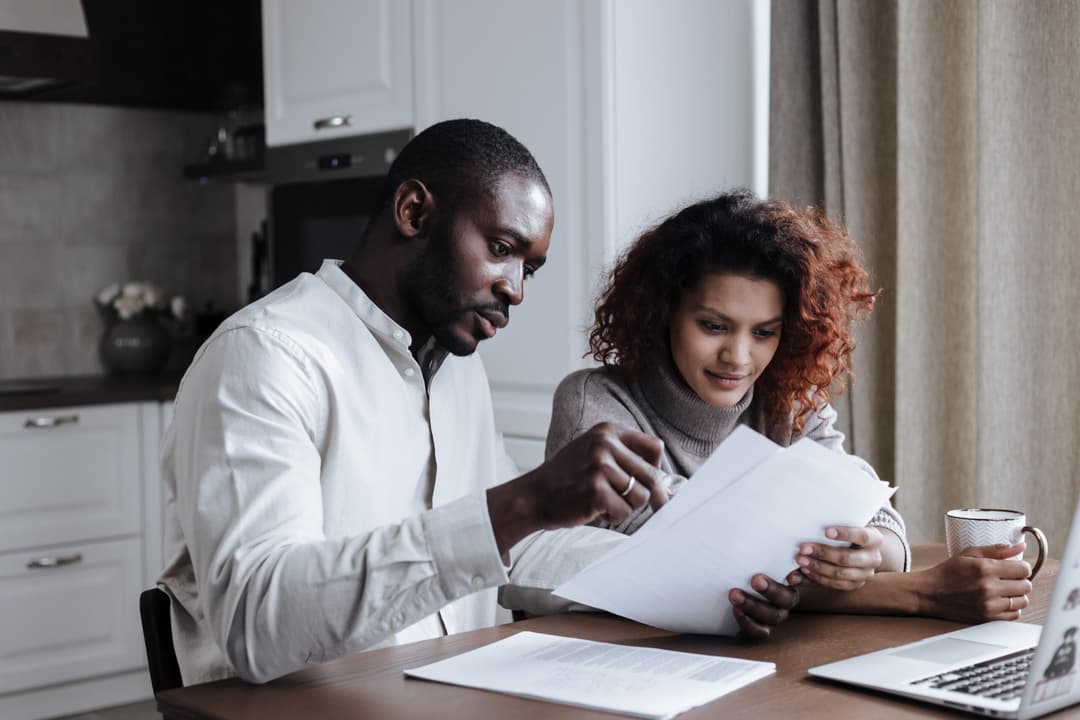 Texas homeowners reviewing property appraisal documents on a laptop at home.